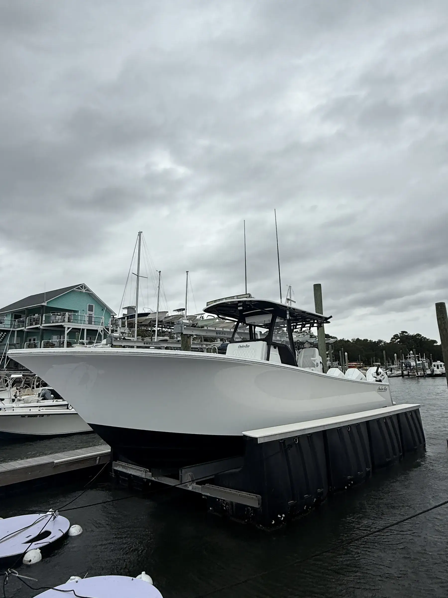 Center console boat resting on a floating boat lift at a marina