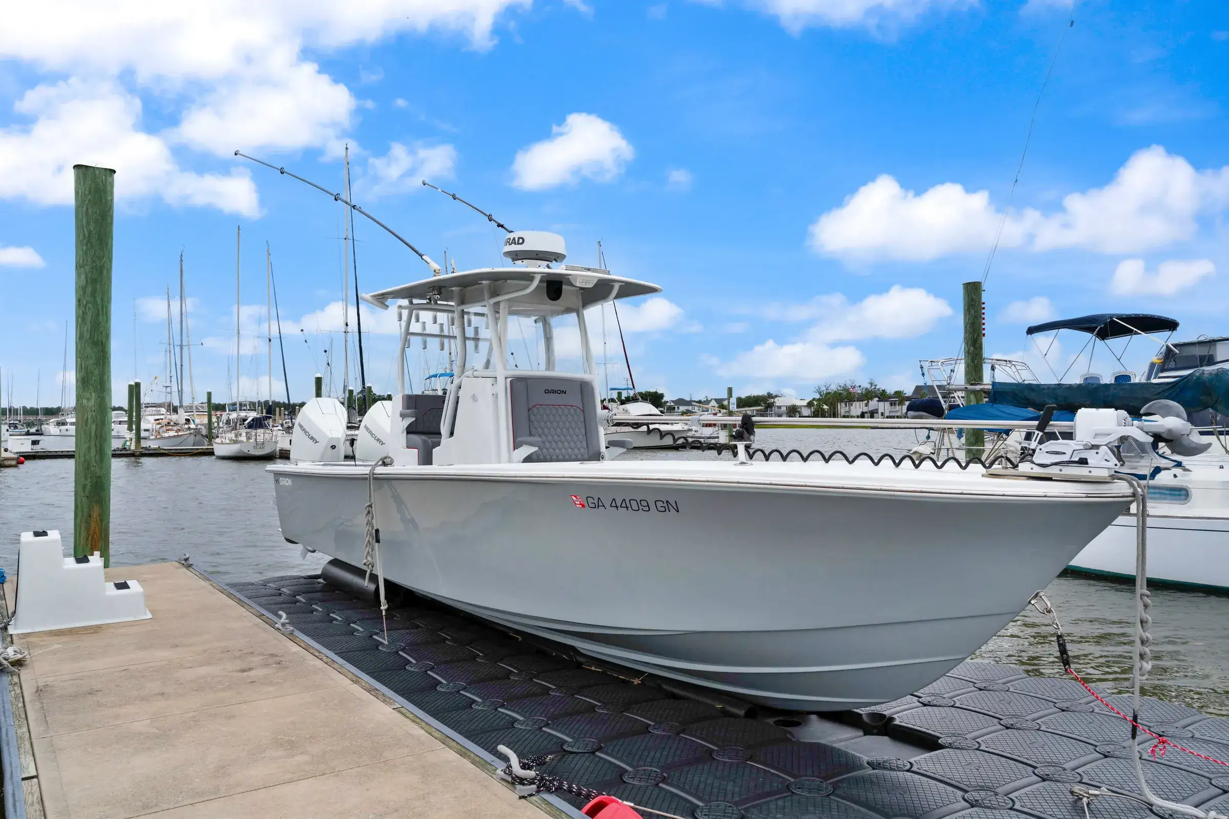 Center console boat sitting on a drive-on floating boat lift at a marina